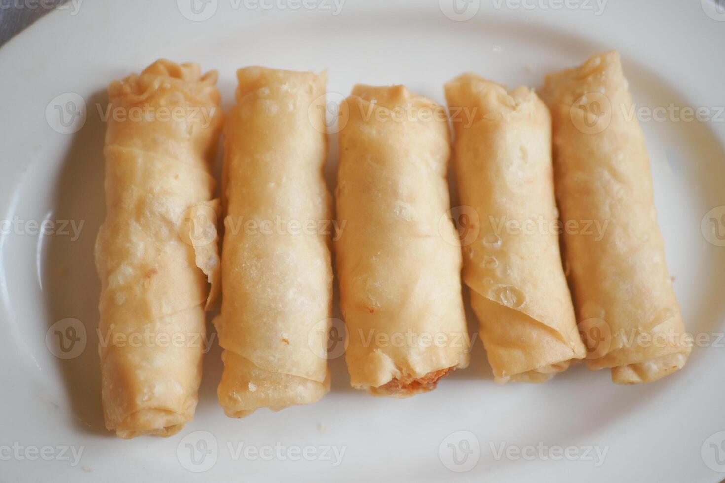 Crispy spring rolls served on a white plate for lunch photo
