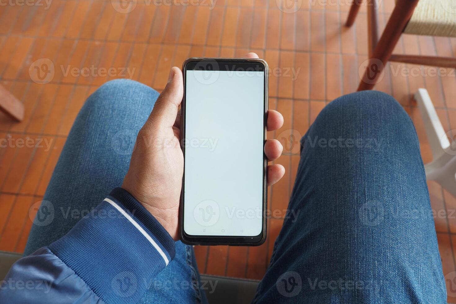 Person holding smartphone in hands while sitting photo