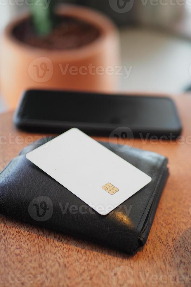 Wallet and card resting on wooden table near smartphone photo