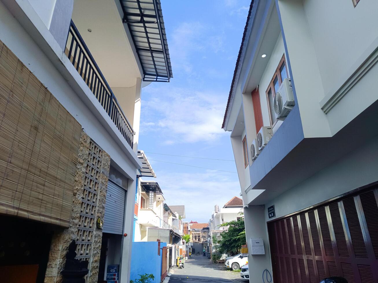 Bali, Indonesia - May 28, 2025 - A narrow alley between two tall buildings with modern architecture, in a housing complex in Pemogan, Denpasar City, Bali in the morning. photo