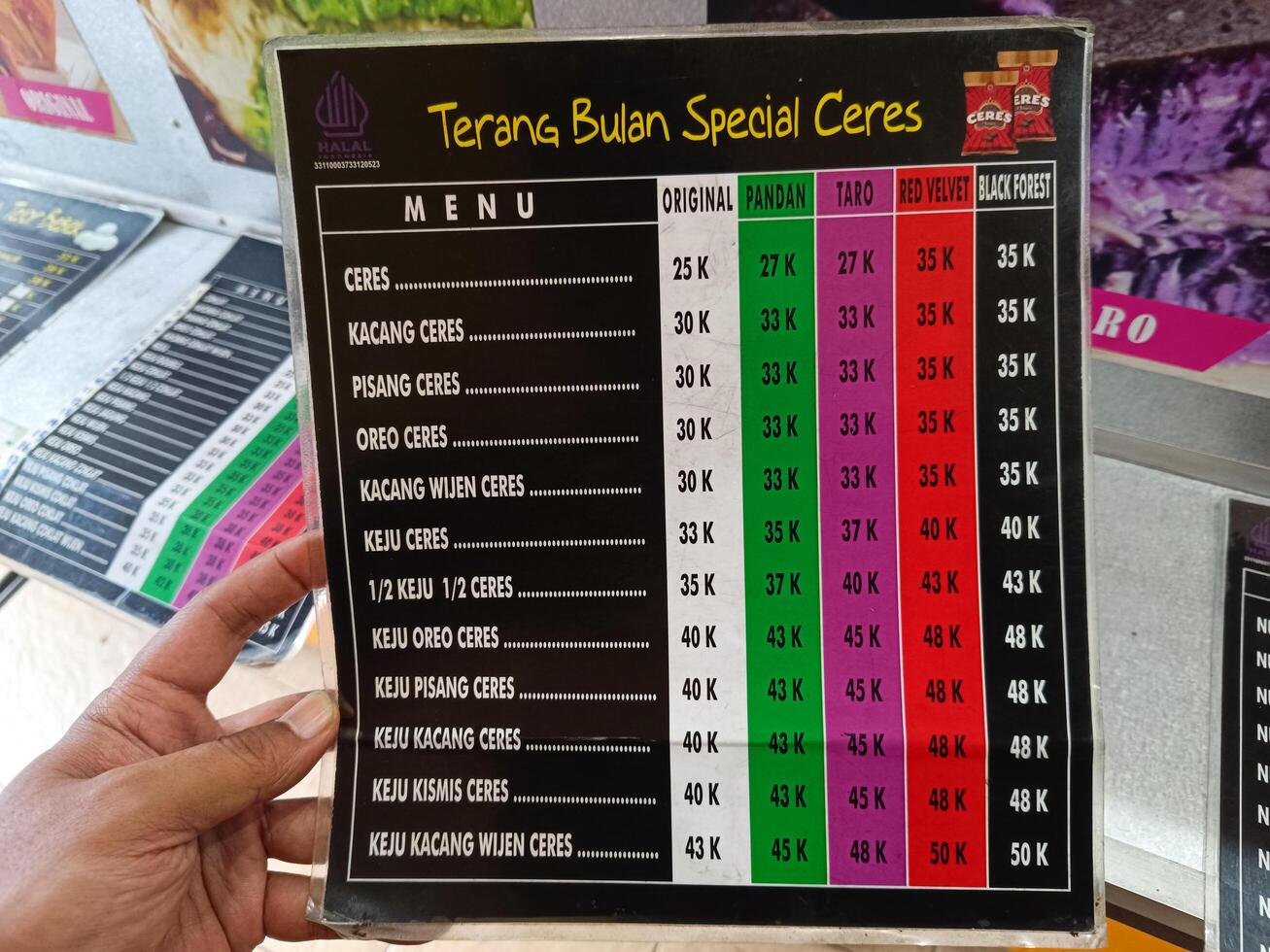 Bali, Indonesia - May 09, 2025 - Menu list of Terang Bulan Spesial Ceres with various flavors, toppings and prices at street food stalls in Tabanan City, Bali. photo