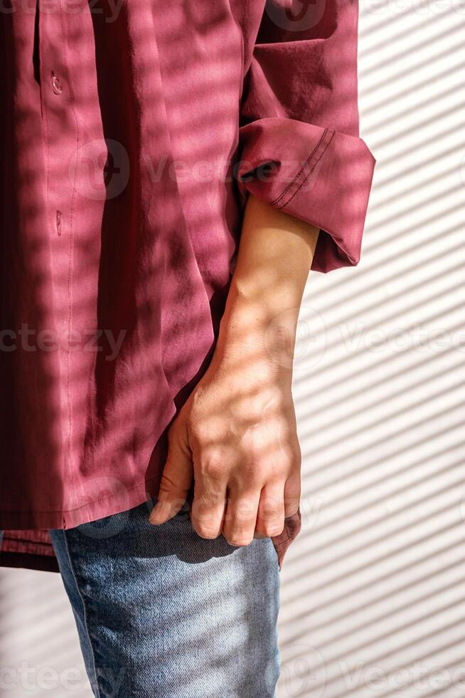 Females Hand on Jeans Pocket with Shadow from Blinds. Natural Light and Shadow Play. photo
