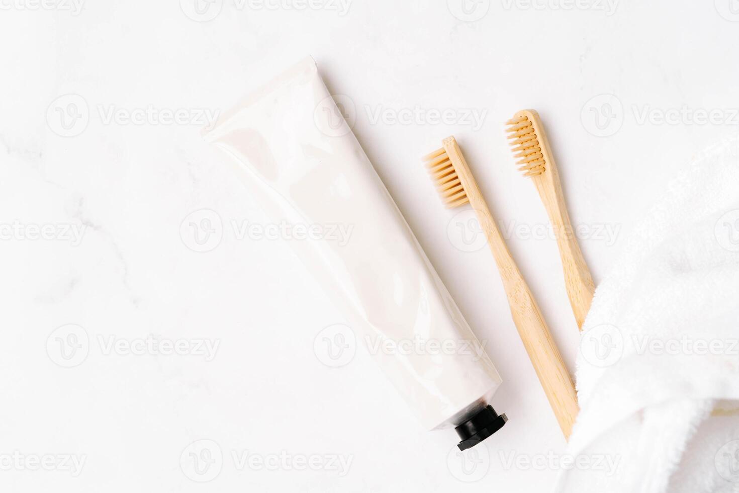 Top view of white metal tube without label and toothbrushes photo