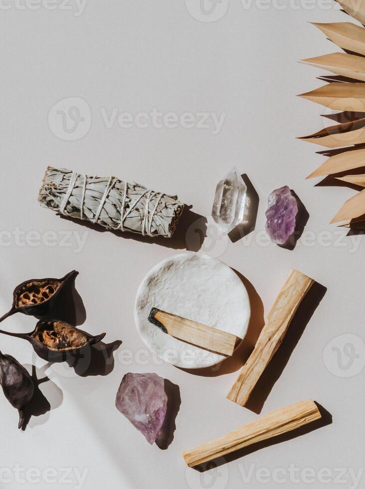 White sage and Palo Santo and amethyst and quartz crystals on a light beige background. photo