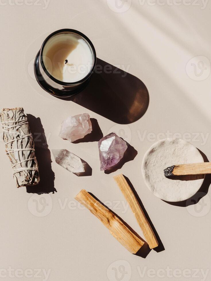 White sage and Palo Santo and amethyst and quartz crystals on light beige background photo