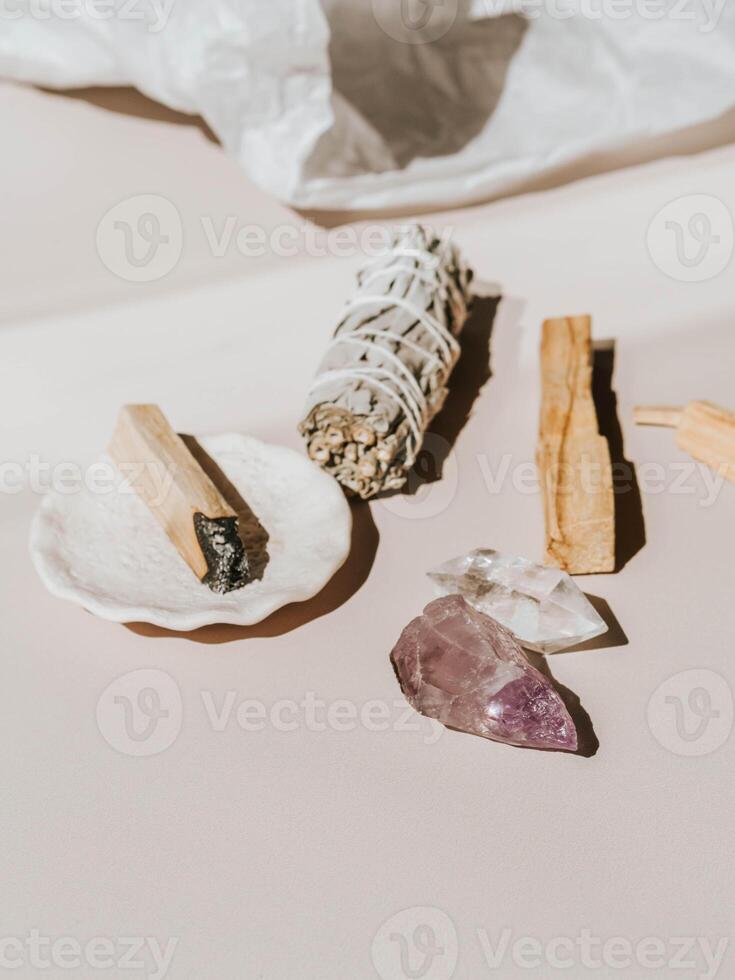 White sage and Palo Santo and crystals on a light beige background photo