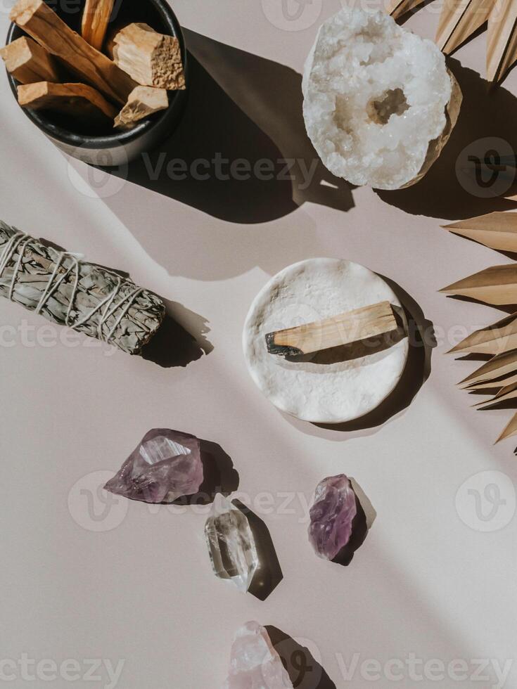 White sage and Palo Santo and amethyst and quartz crystals on a light background photo