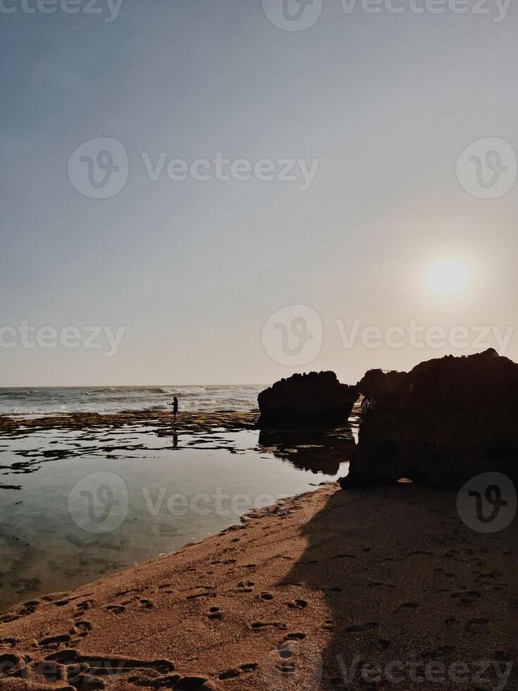 Sunset Reflection on Beach Rocks photo