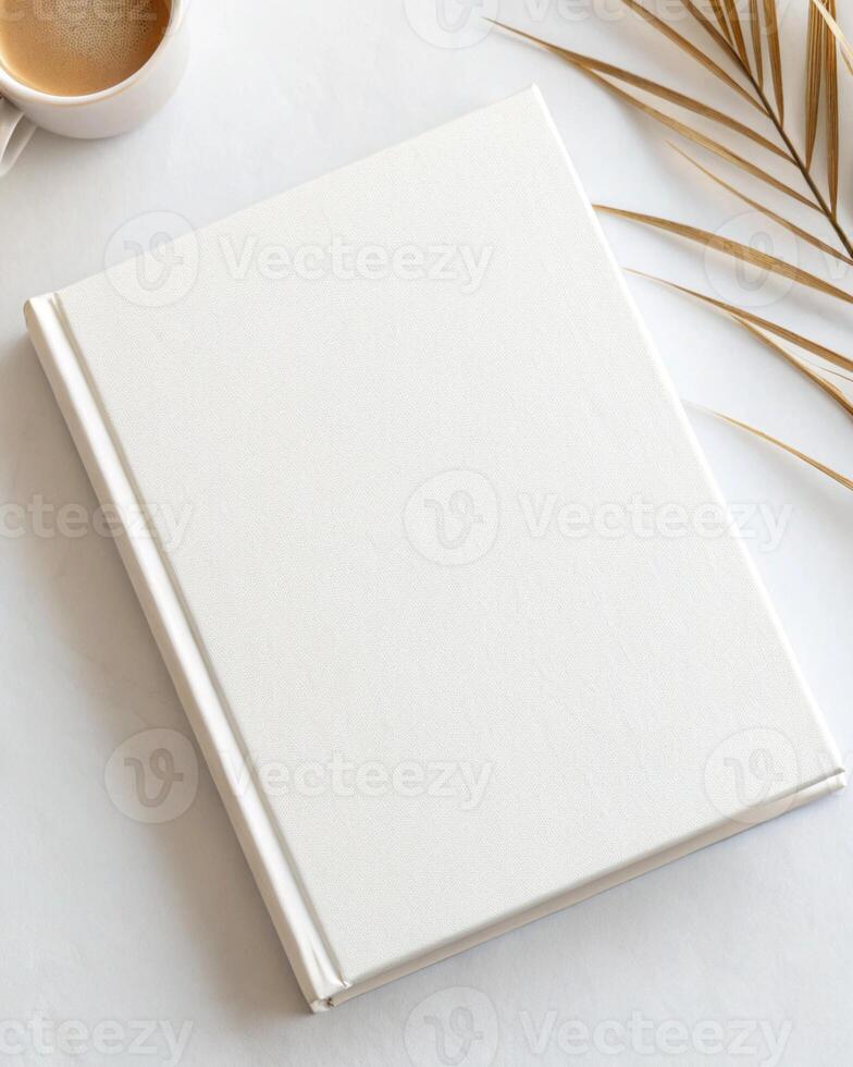 White blank notebook with palm leaves on white marble photo