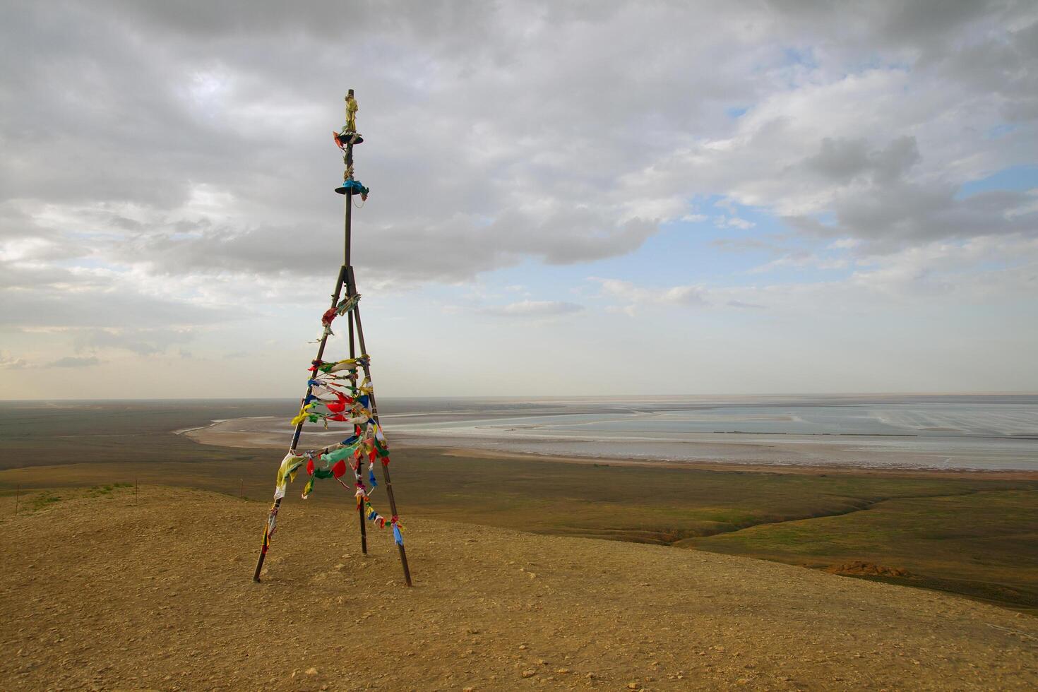Triangulation mark with buddhist prayer flags near lake Baskunchak photo