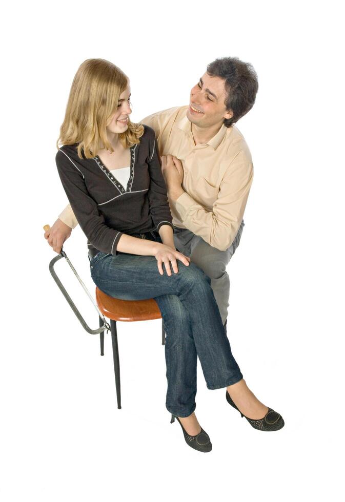 Humorous photo of a man sawing off a leg of woman's chair