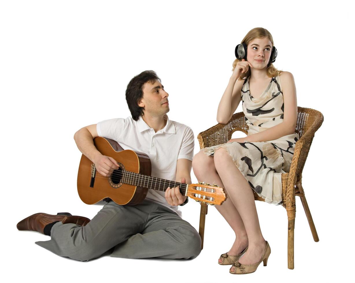 Man serenading to a girl wearing headphones photo