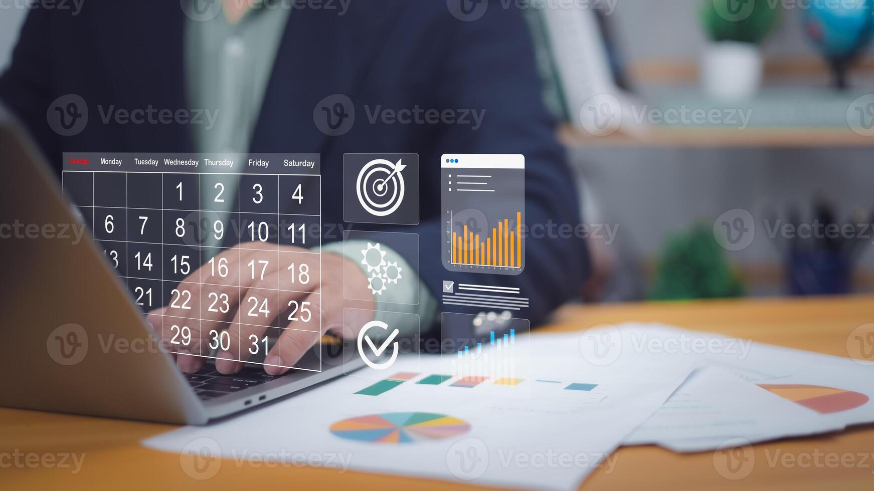 Hand on laptop with digital calendar, target, charts. Symbolizes digital scheduling, project planning, goal setting. Ideal for business management, productivity, data analysis, strategic execution now photo