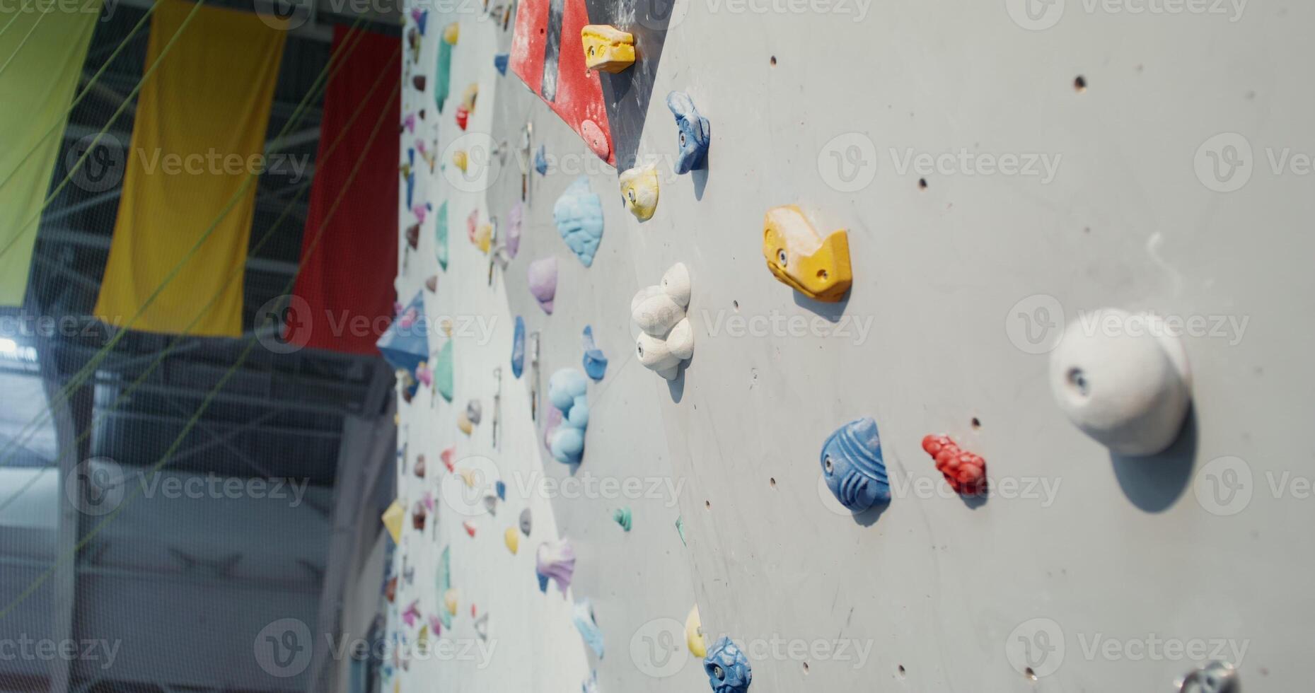 A modern indoor sports hall with a Rock Climbing Wall for training climbers. Shooting a climbing wall with many irregularities and angles, close ups without people. photo