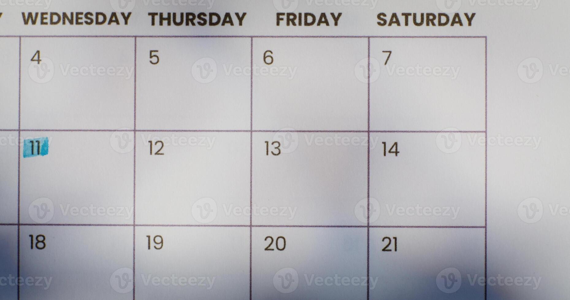 A woman crosses out a date on a calendar or a glider with a red marker. Close up of her hand, unrecognizable person photo