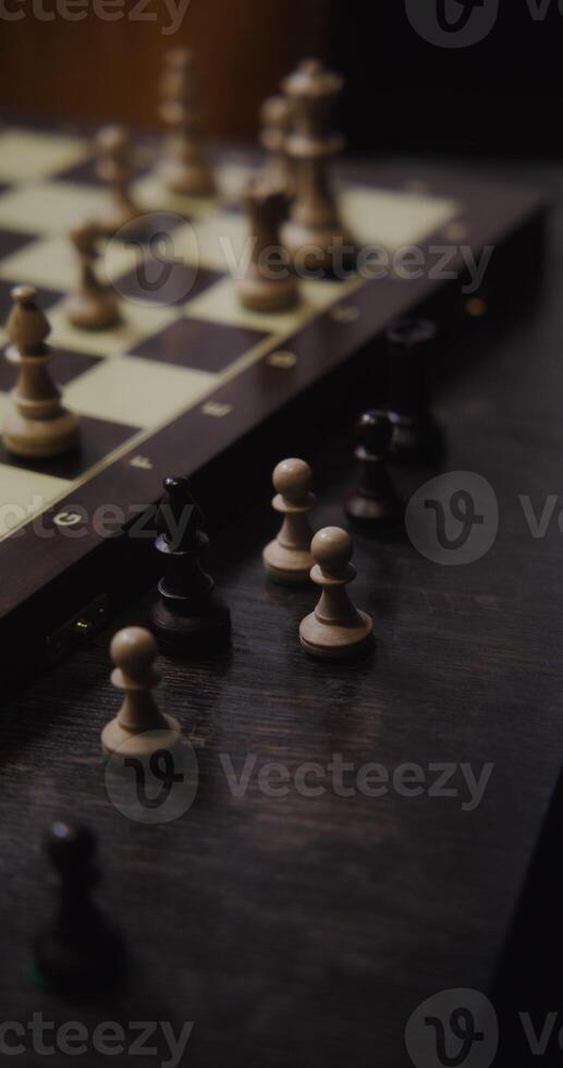 Male hand rearranges pieces on the chessboard, close up. Playing chess alone, filming without a face, unidentified person, vertical photo
