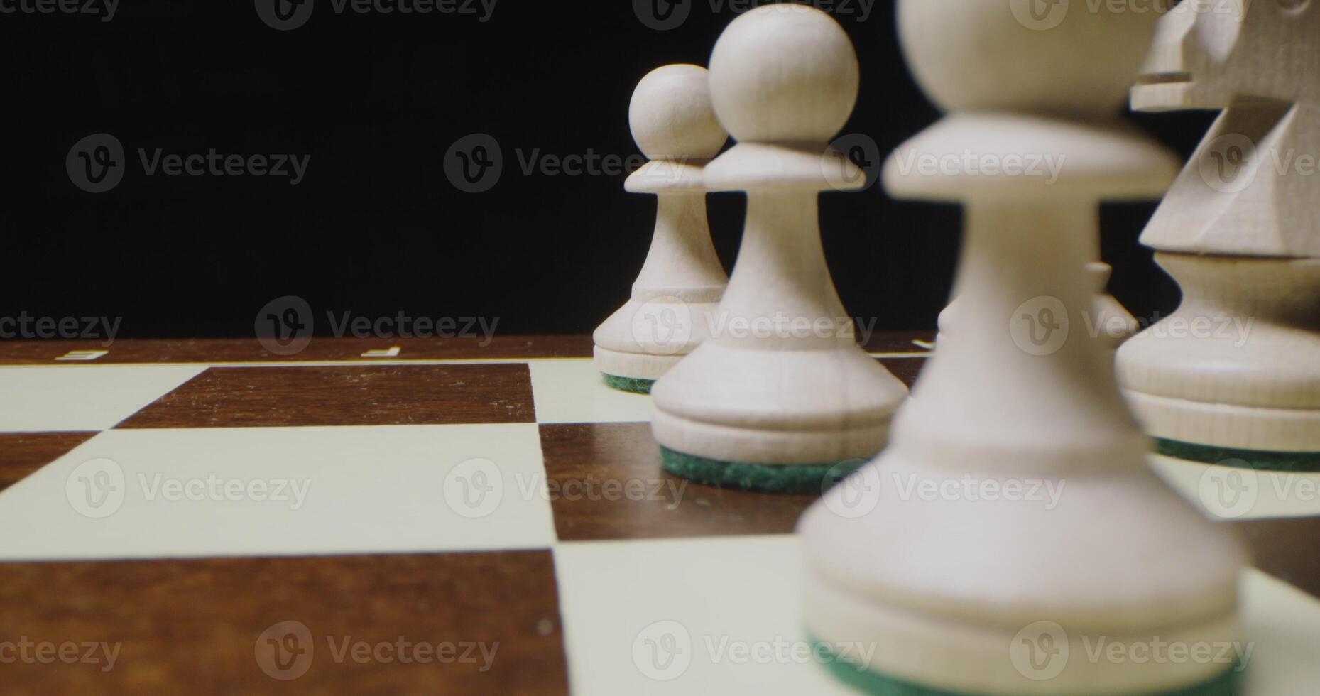 White chess pieces lined up in even rows on a game board, ready for a game photo