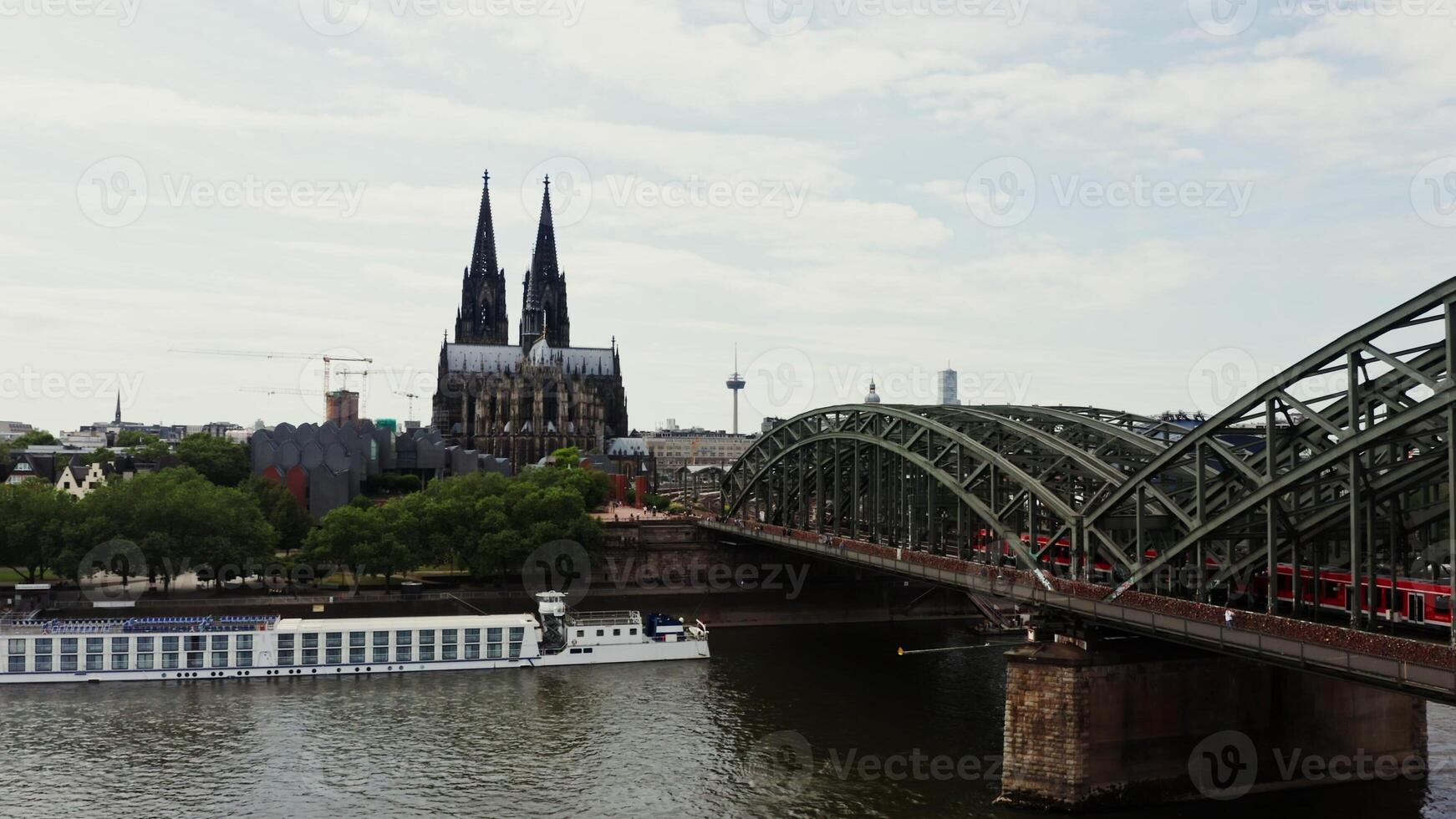 Railway bridge with train moving over it from a bird's eye view. Panoramic shooting from a drone, view of the historic center of Cologne, Germany. photo