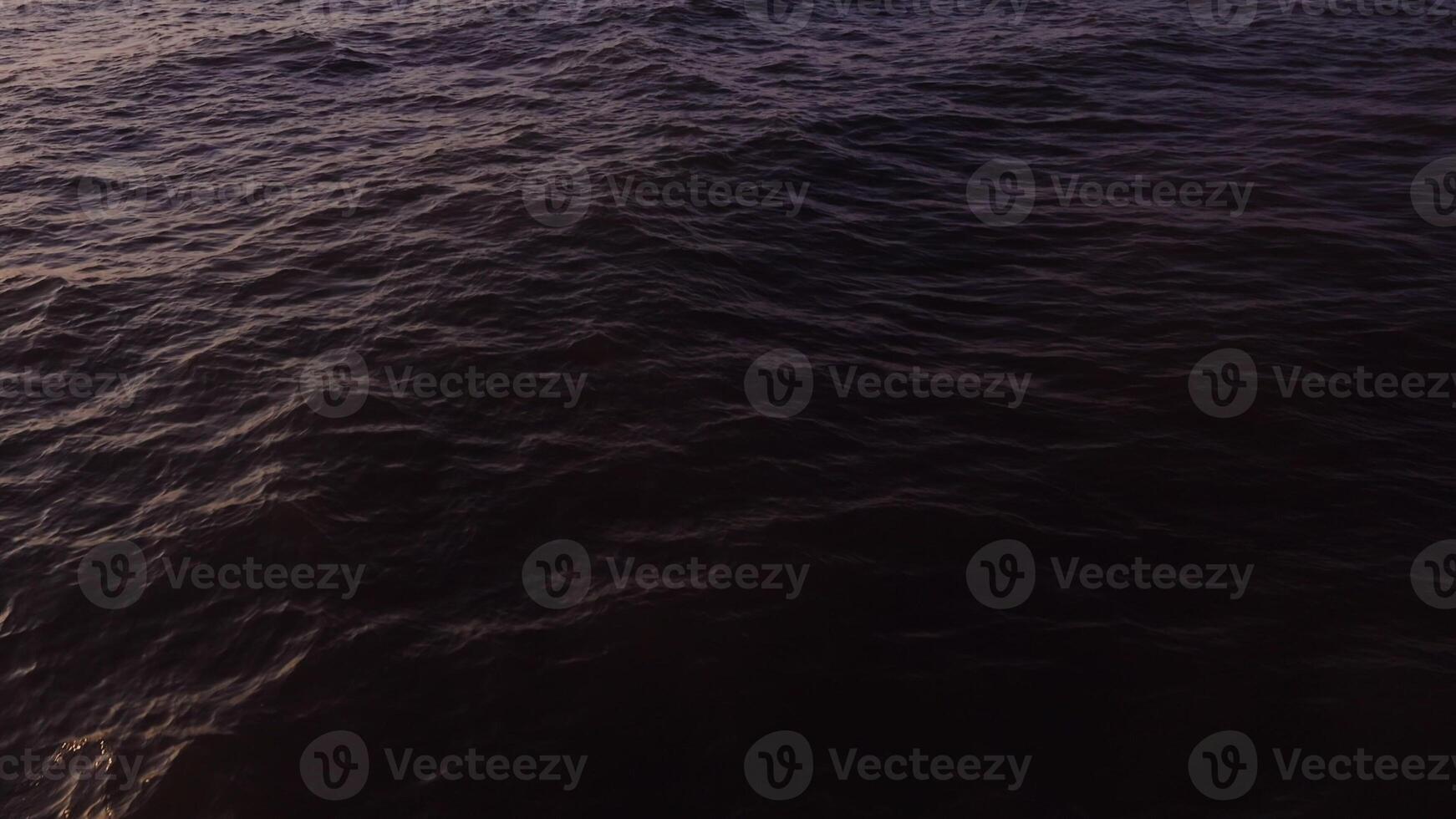 A boat is sailing in the ocean at sunset photo