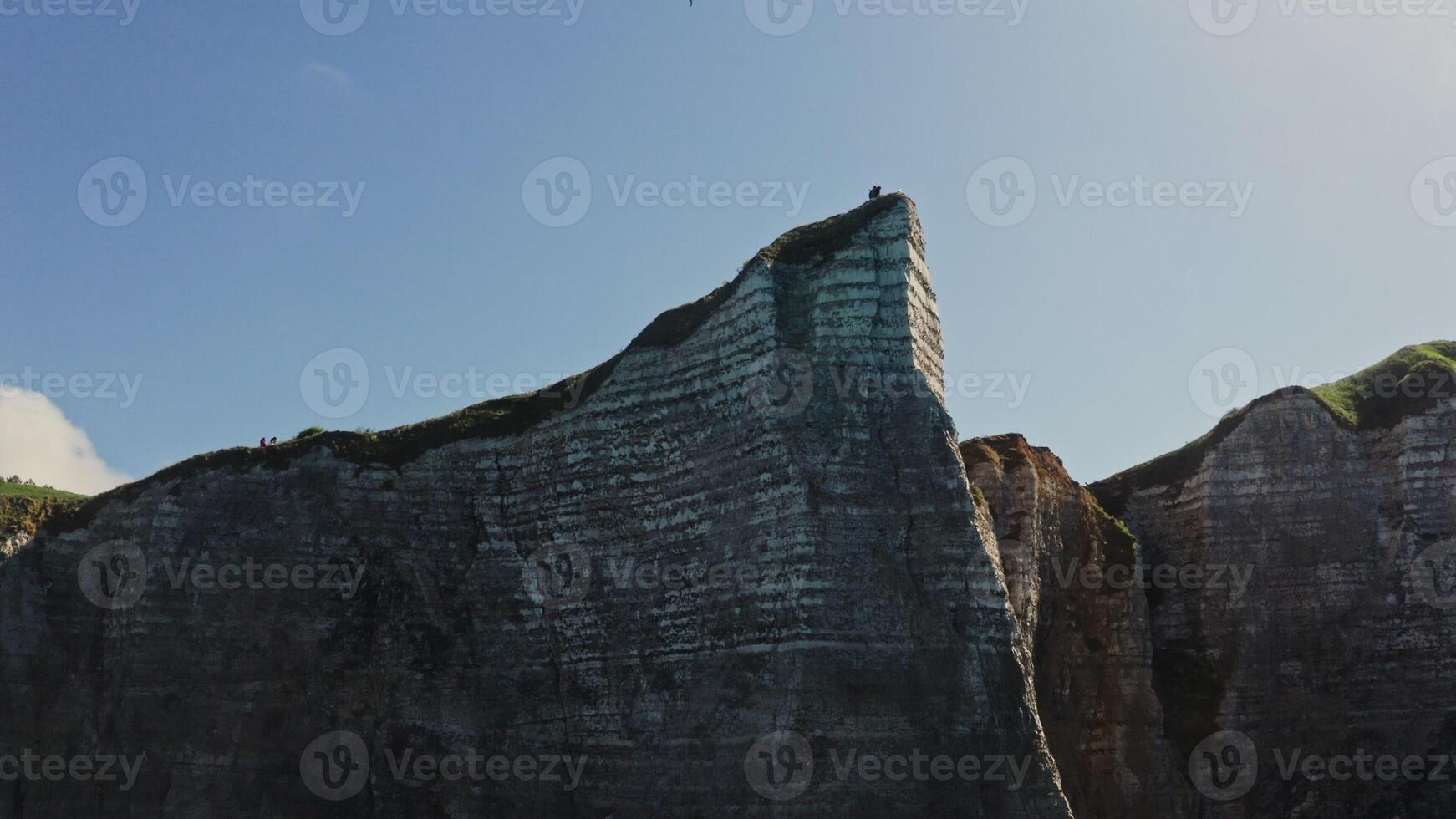 A person standing on top of a cliff photo