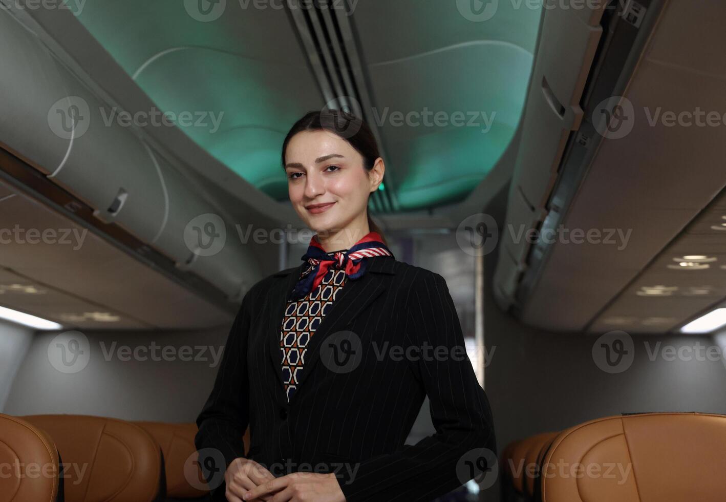 A friendly flight attendant stand confidently inside an airplane cabins. photo