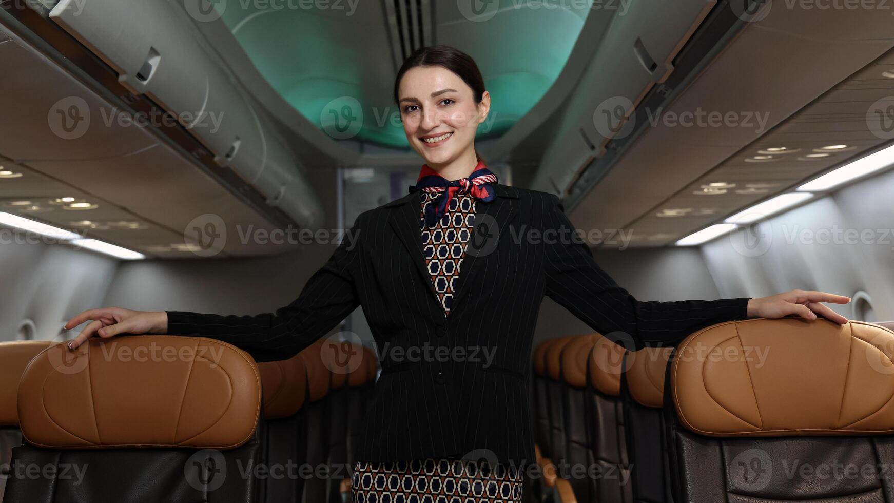 friendly flight attendant stand confidently inside an airplane cabin. photo