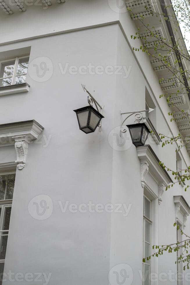 Elegant White Building With Classic Lanterns Illuminated at Dusk Showcasing Architectural Details and Charm in a Tranquil Urban Setting photo