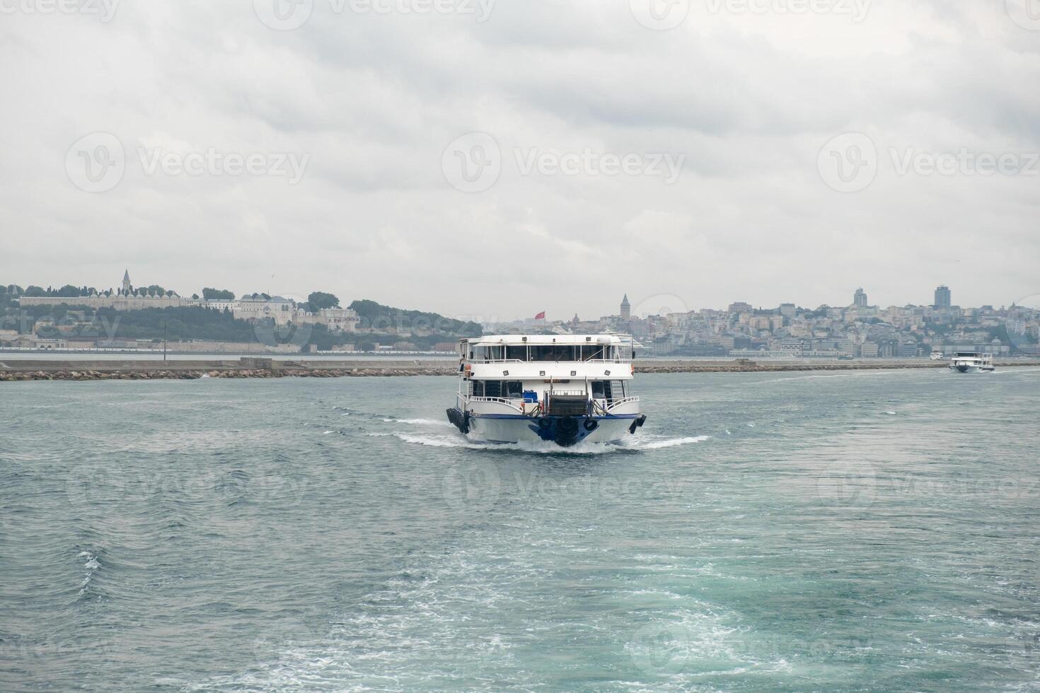 Cruising through the Bosphorus Strait with city views on a cloudy day photo