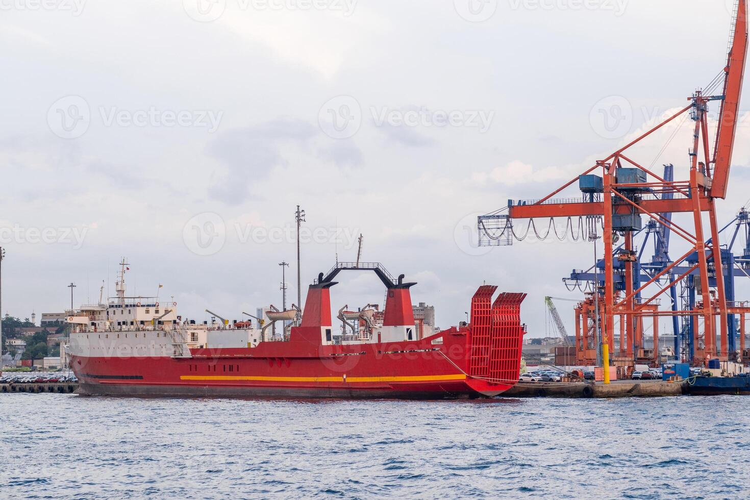 Bosphorus harbor with cargo ship at dock under cloudy skies and industrial cranes in the background photo