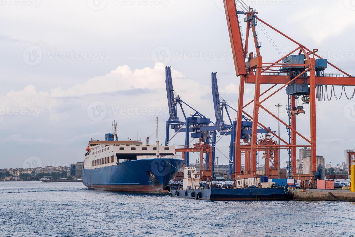 Bosphorus harbor with cargo ship and cranes during cloudy weather at dusk photo