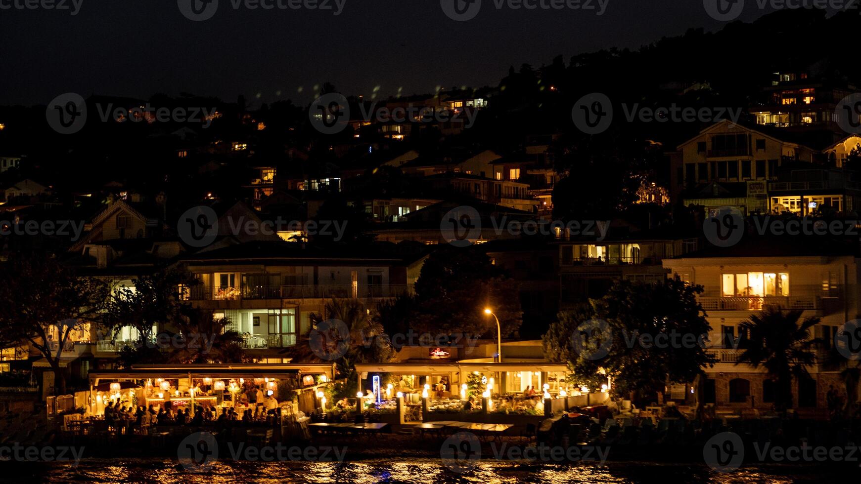 Discover the charm of Prince Islands nightlife with illuminated cafes and serene coastal views at dusk near the waterfront photo