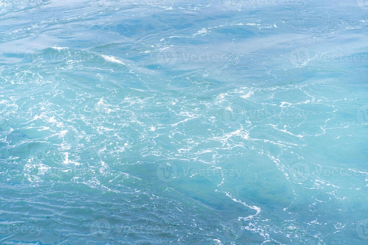 Waves gently lapping at the shores of Prince Islands during a sunny day with vibrant turquoise waters photo