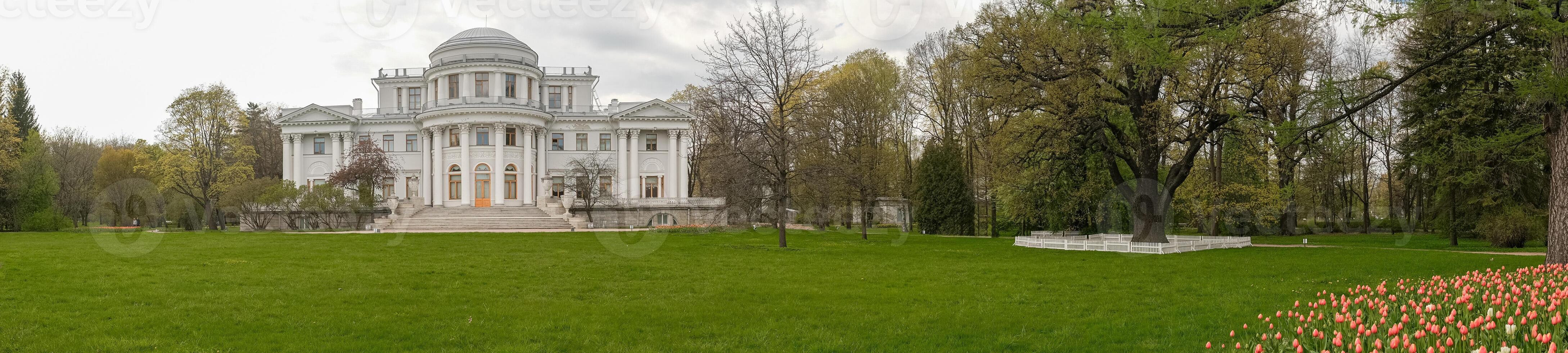 Elegant Historic Mansion Surrounded by Vibrant Gardens and Lush Greenery in Early Spring photo