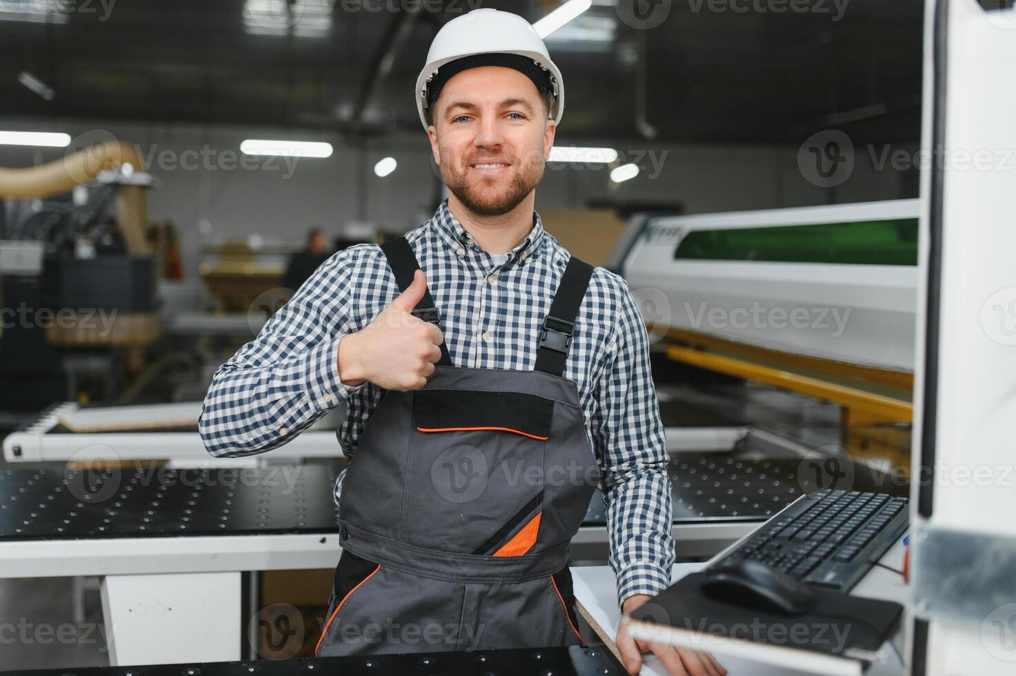 Furniture maker showing thumbs up while working in factory photo