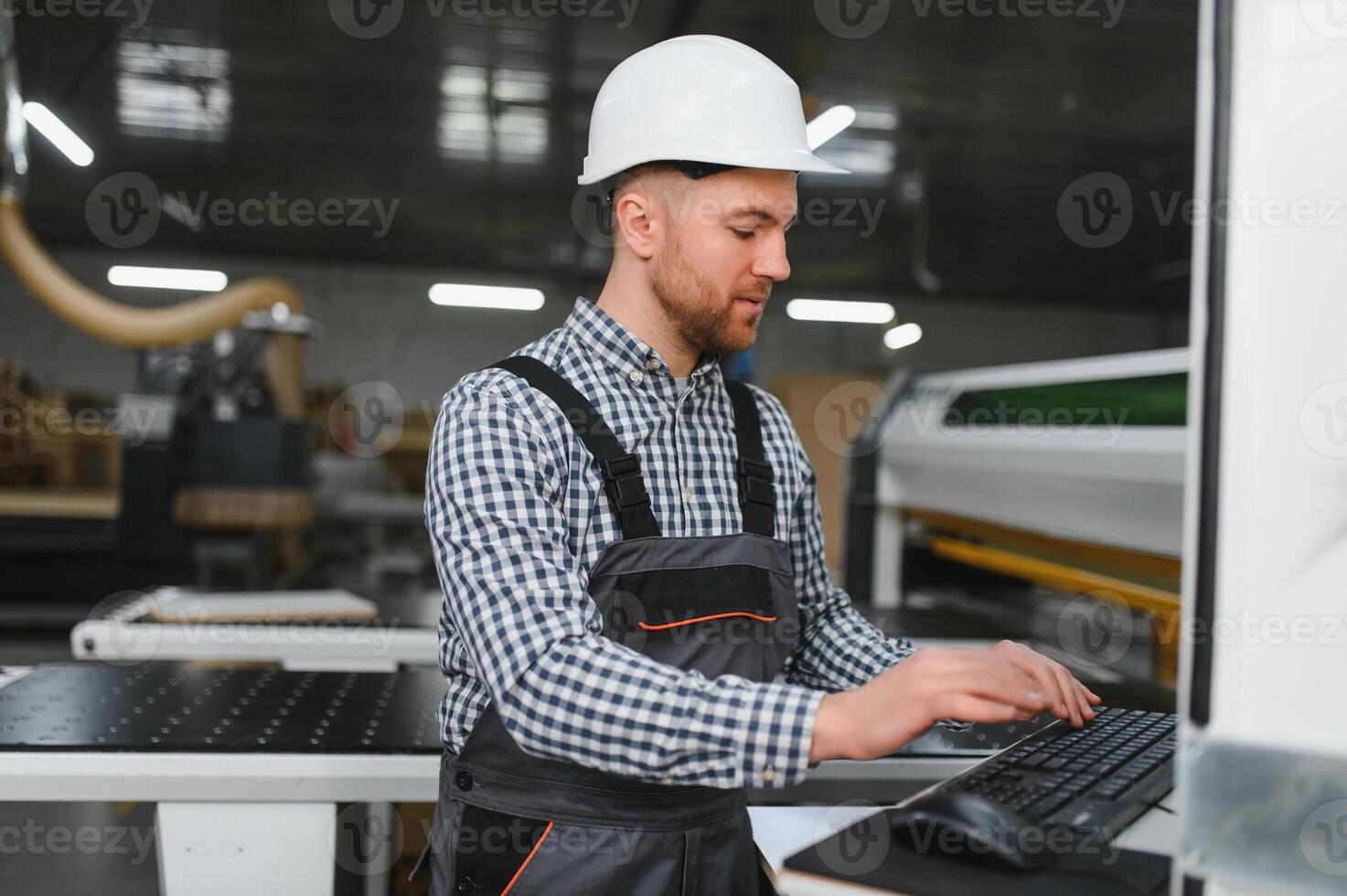 Carpenter programming cnc machine in furniture factory photo