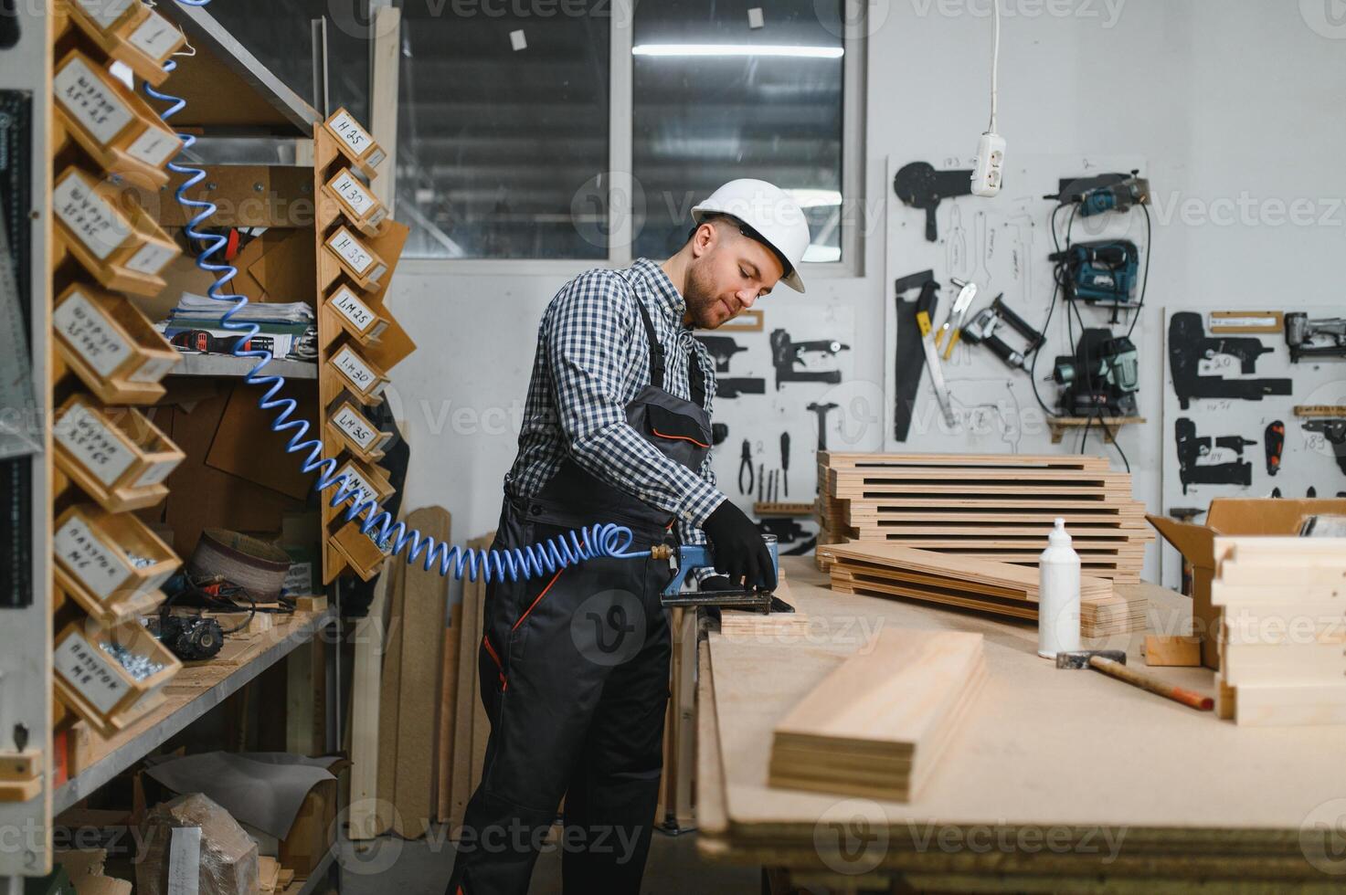 Carpenter working wood in furniture factory using pneumatic tool photo