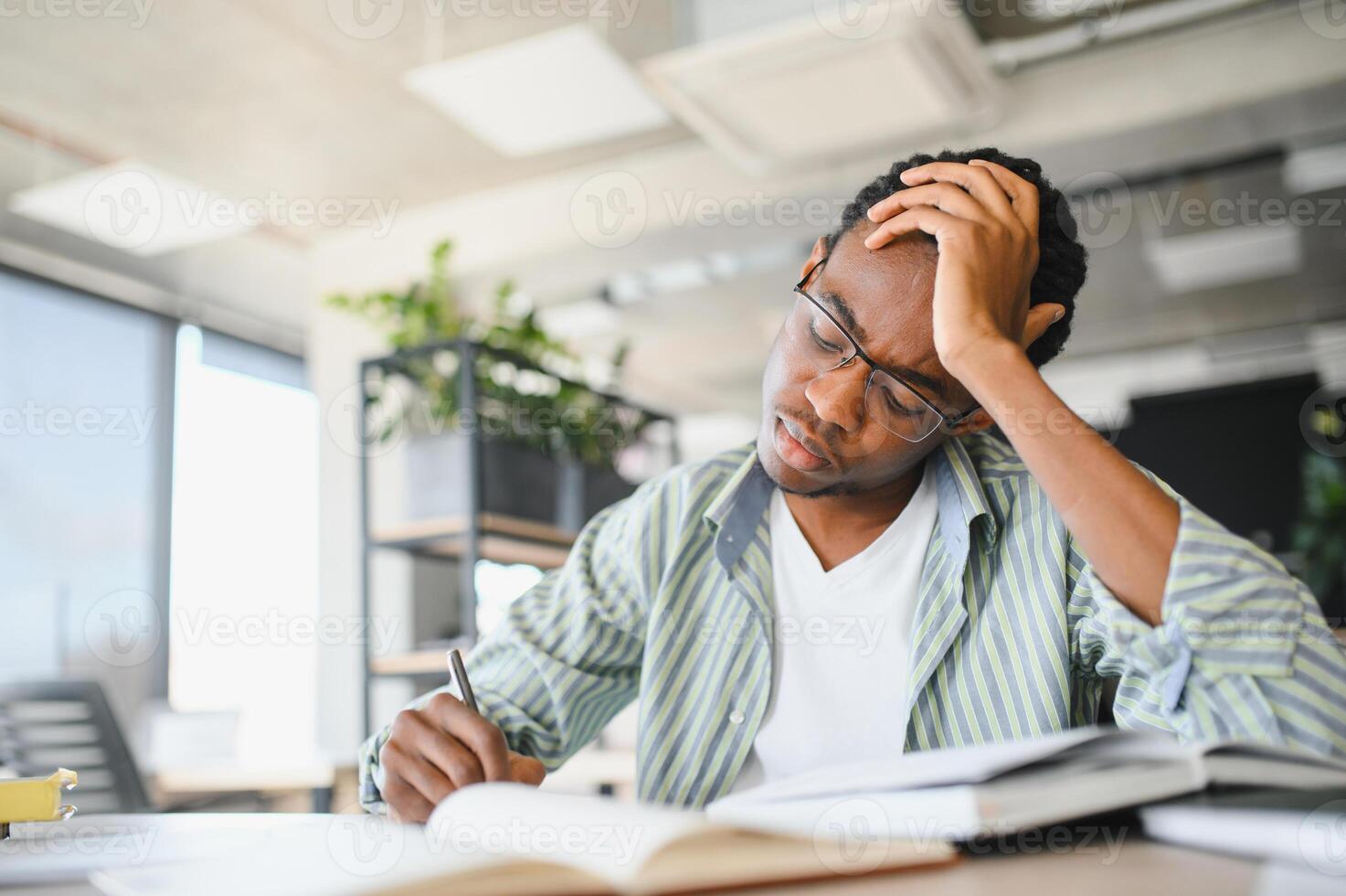 Focused african american student studying hard in university library photo