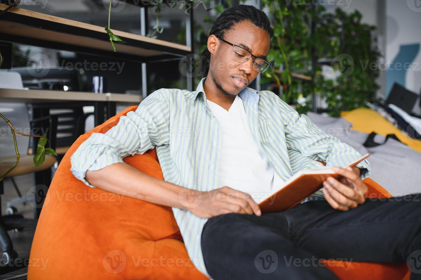 Focused university student reading a book in modern library. photo