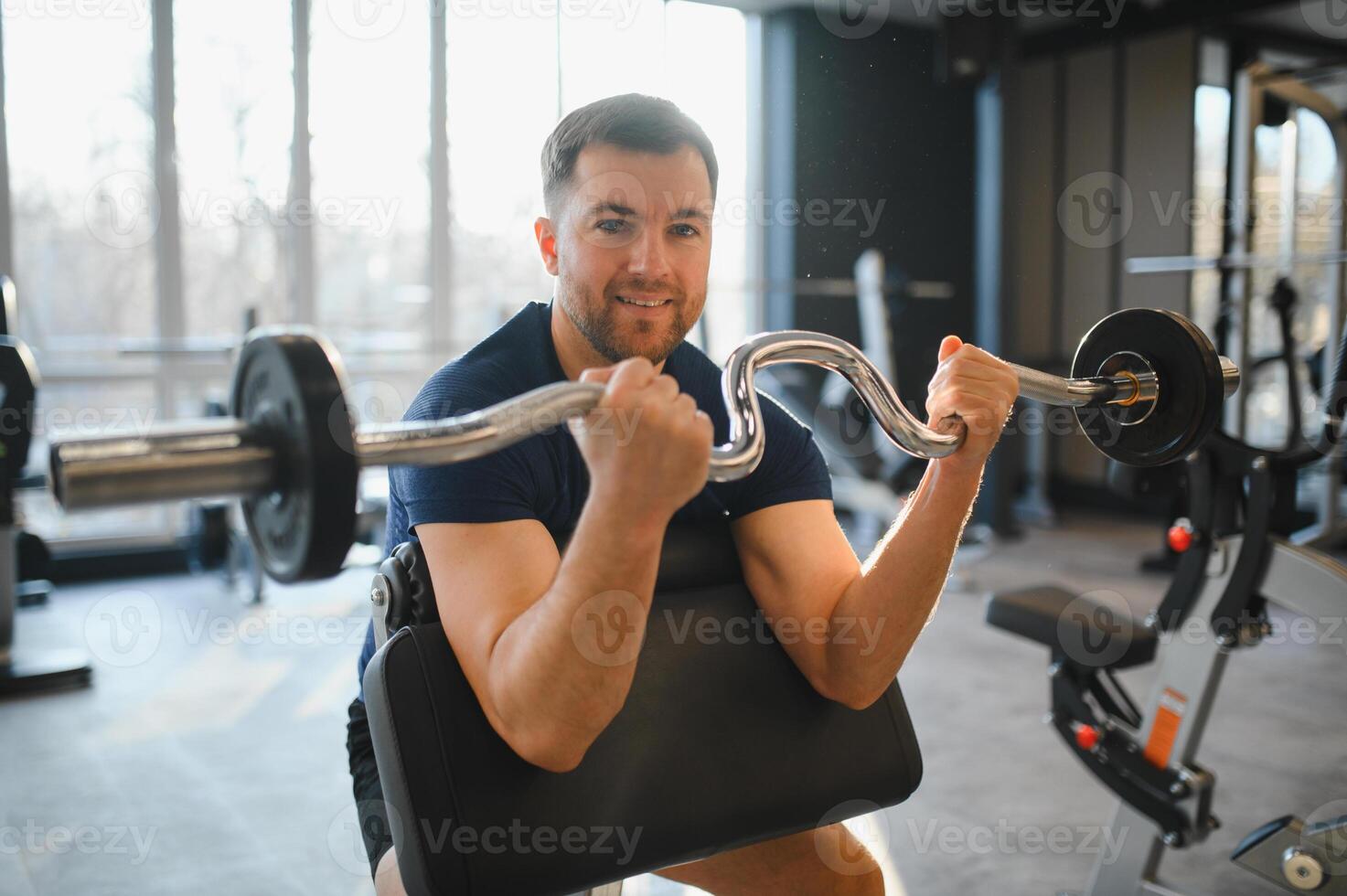 Man lifting weights, exercising biceps in rehabilitation gym photo