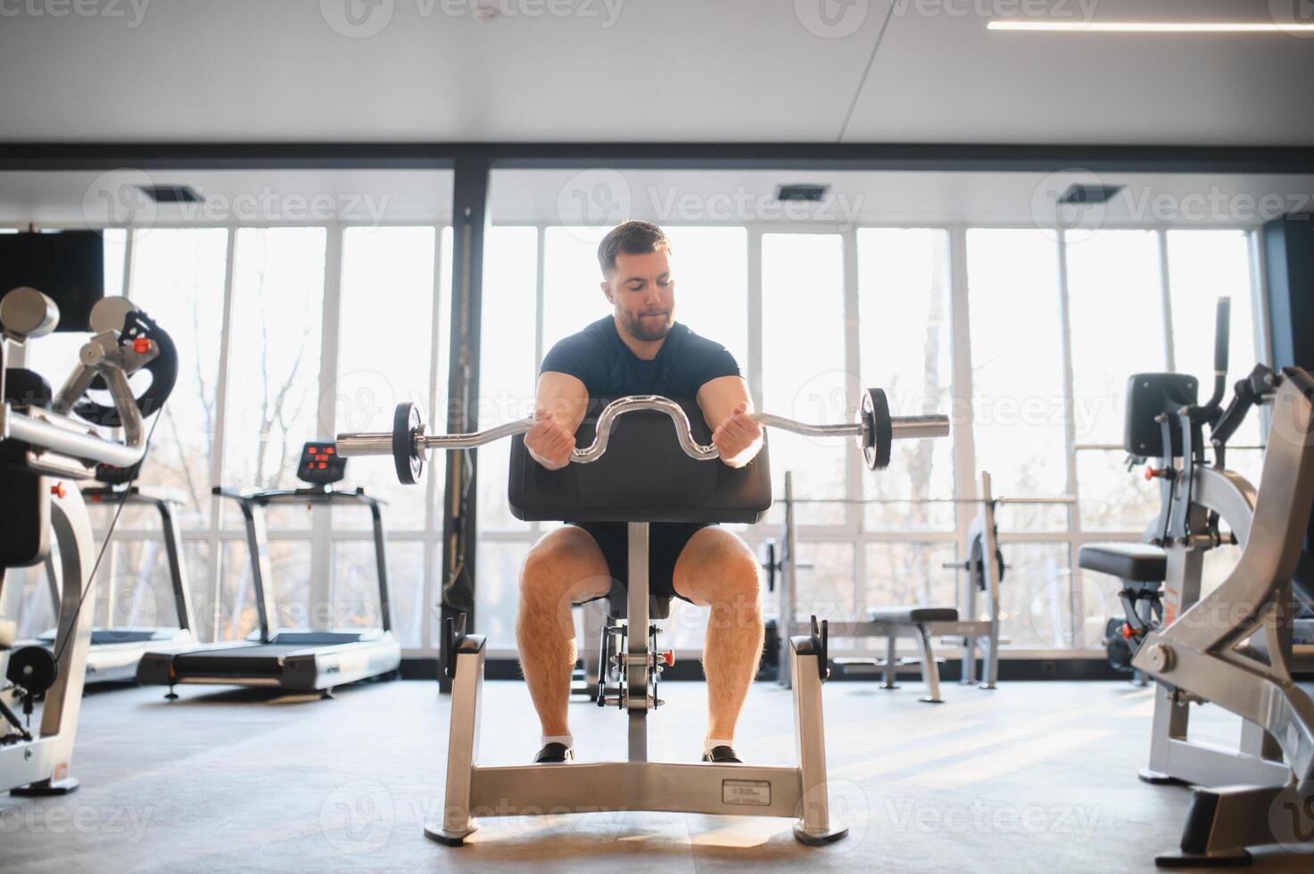 Determined man lifting weights in a modern gym for rehabilitation and recovery photo