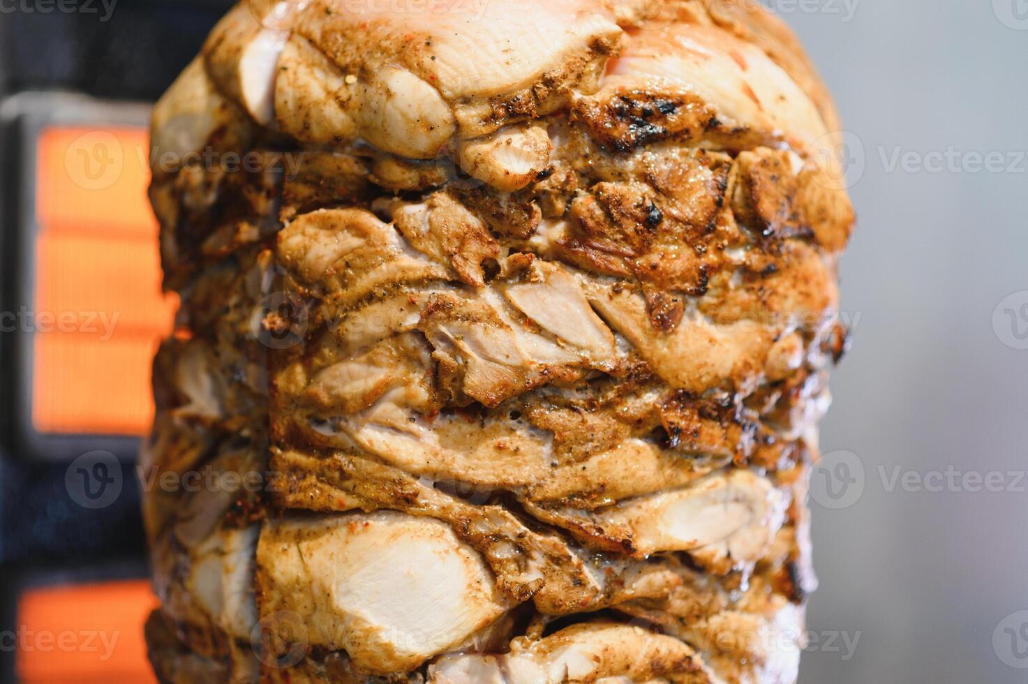 Delicious shawarma rotating on a spit getting cooked by an electric heater photo