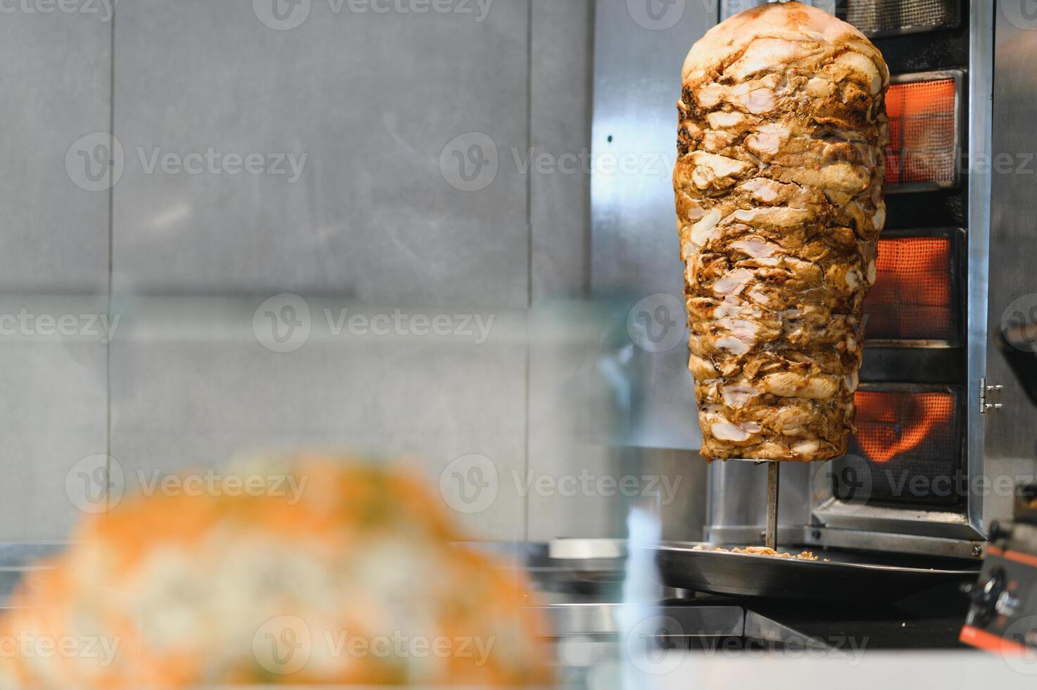 Shawarma rotating on a spit roasting in a fast food restaurant photo