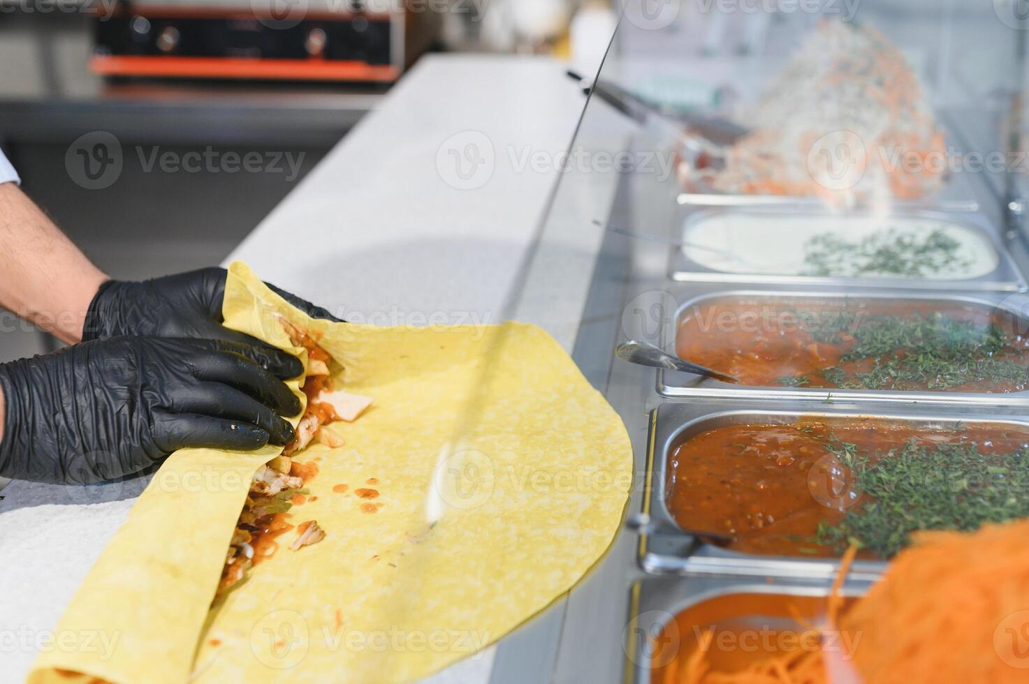 Chef preparing shawarma or kebab using fresh ingredients photo