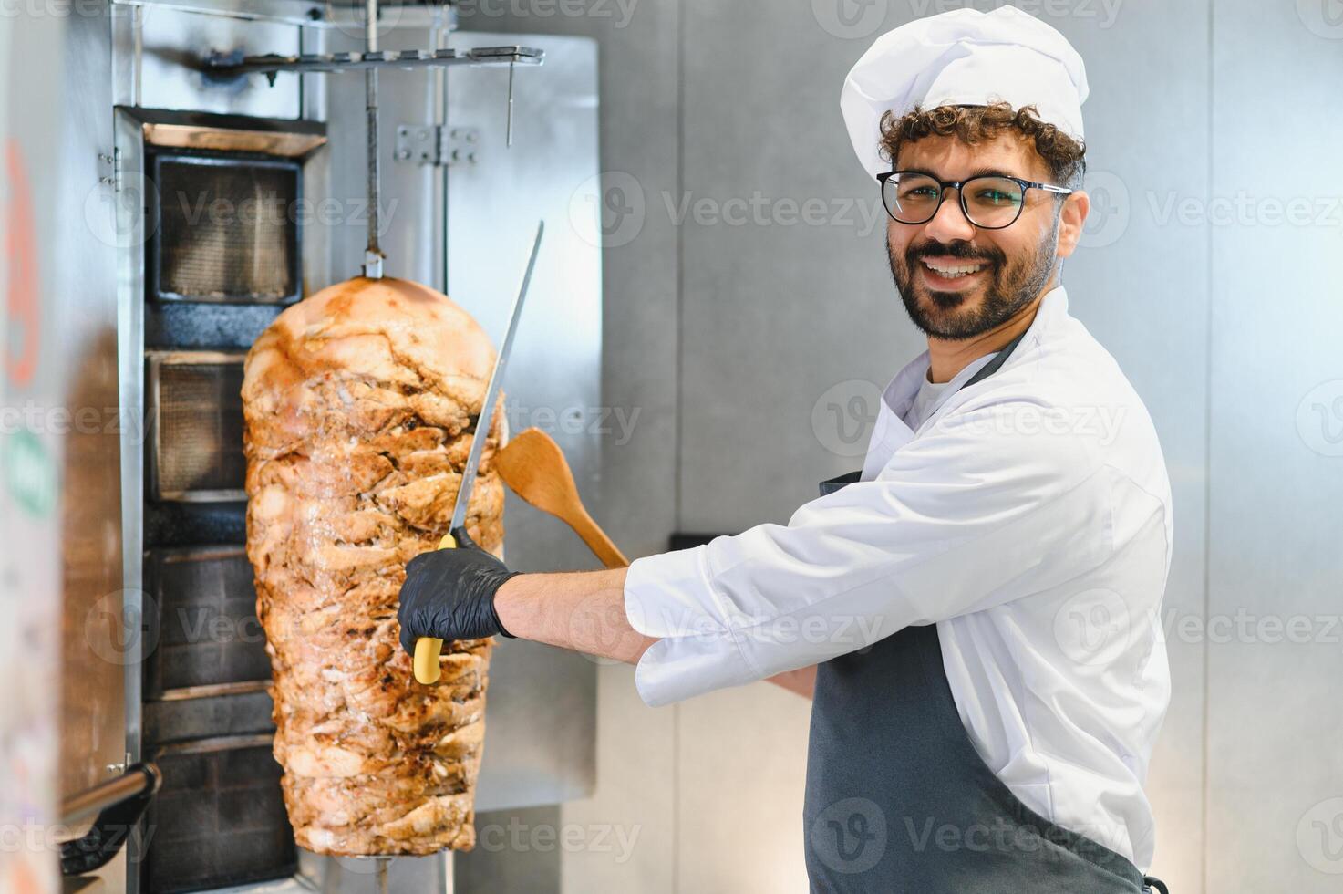 Chef slicing shawarma meat with knife and spatula photo