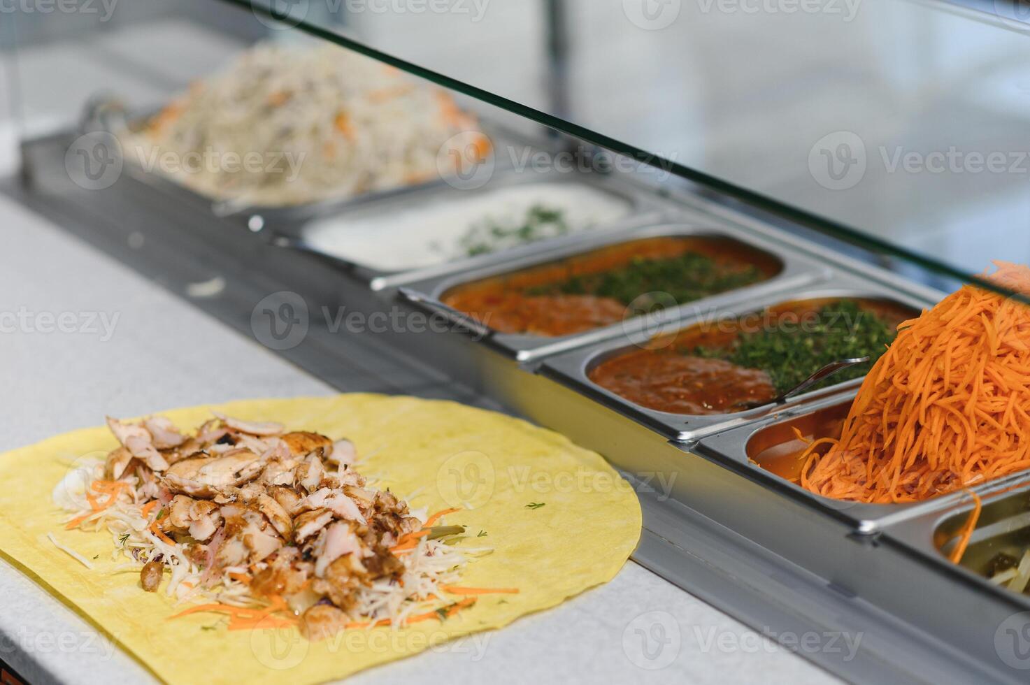 Chef preparing delicious shawarma with chicken and various ingredients photo