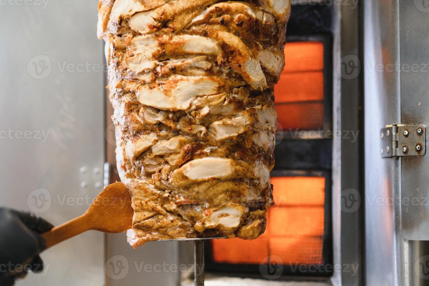 Chef preparing shawarma or doner kebab with chicken meat in a restaurant photo