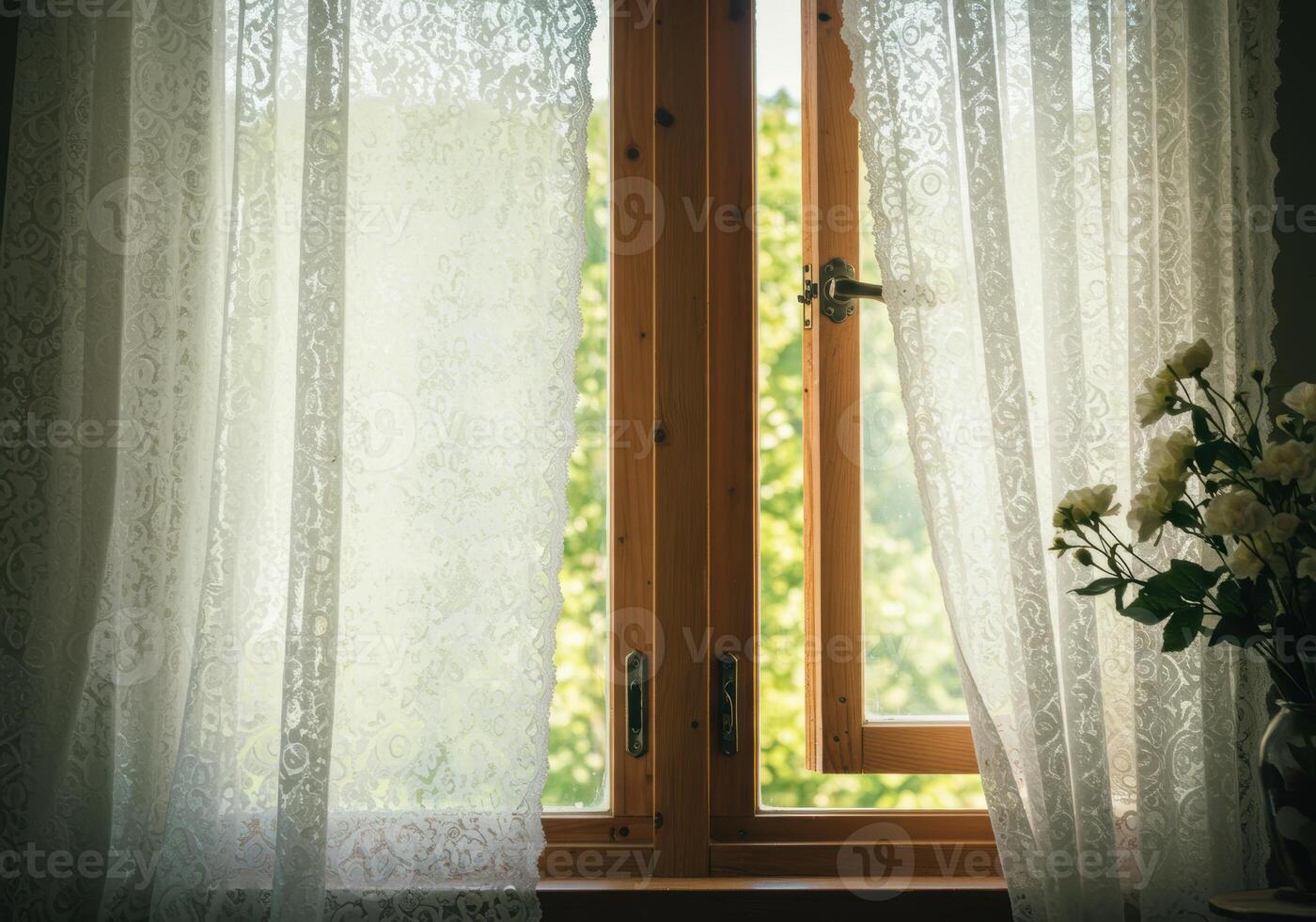 A light-filled room is seen, with open windows and white lace curtains. photo