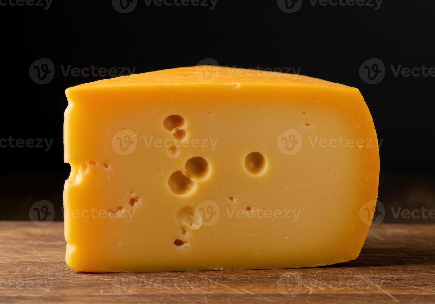 A delightful wedge of cheese with visible holes, presented beautifully on a wooden surface. photo