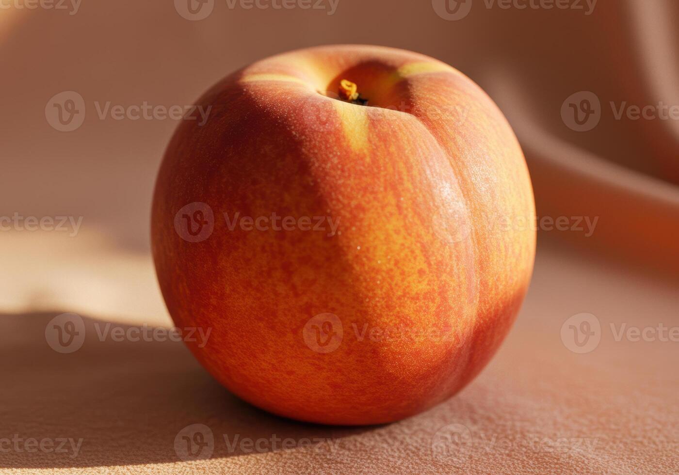 A perfectly ripe nectarine sits under soft light, showcasing its vibrant colors. photo