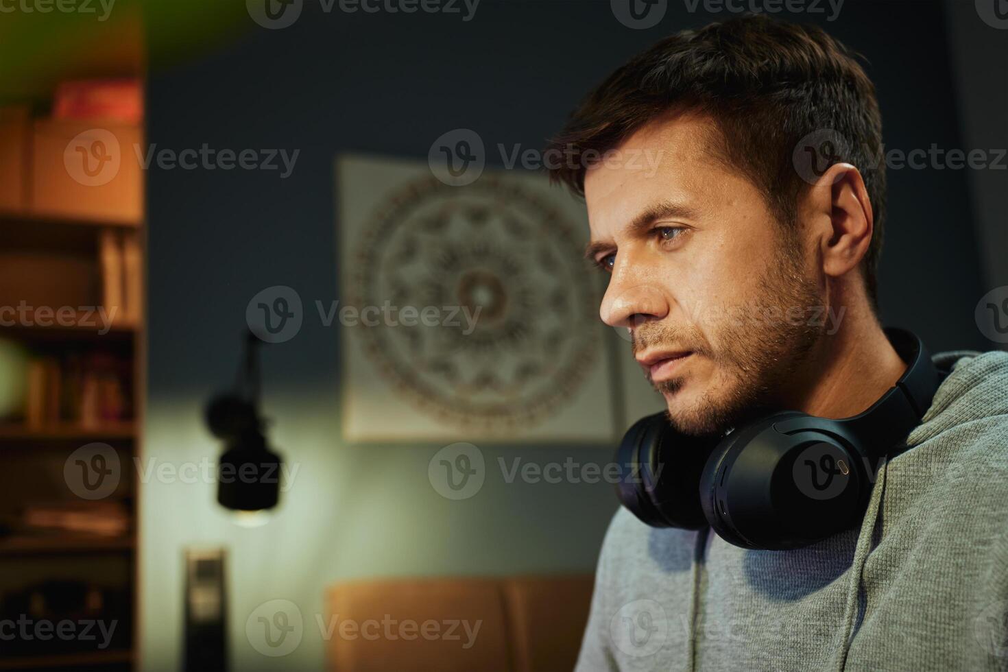 Man sitting at desk and looking at computer monitor. Freelancer focused on screen while working remotely. Concept of concentration, productivity and digital freelance work photo